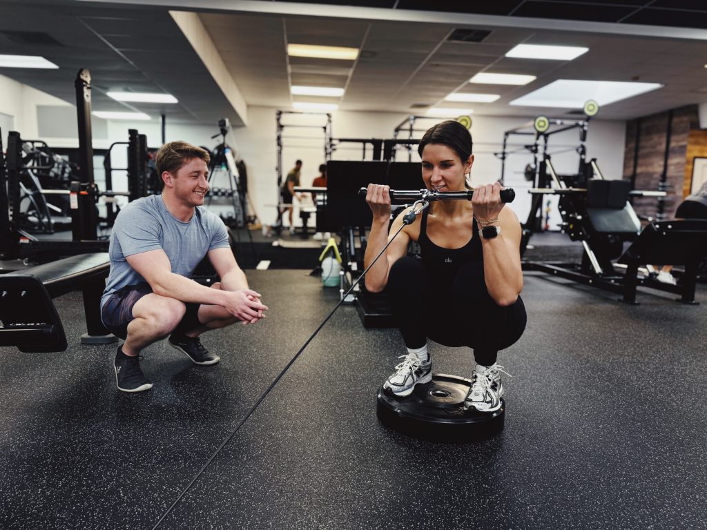 Personal Trainer demonstrating a bicep curl to his client